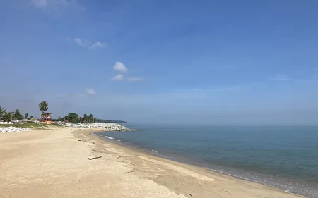 Pantai berpasir di Kota Bharu: air laut biru kehijauan dan rumah chalet di tepi pantai